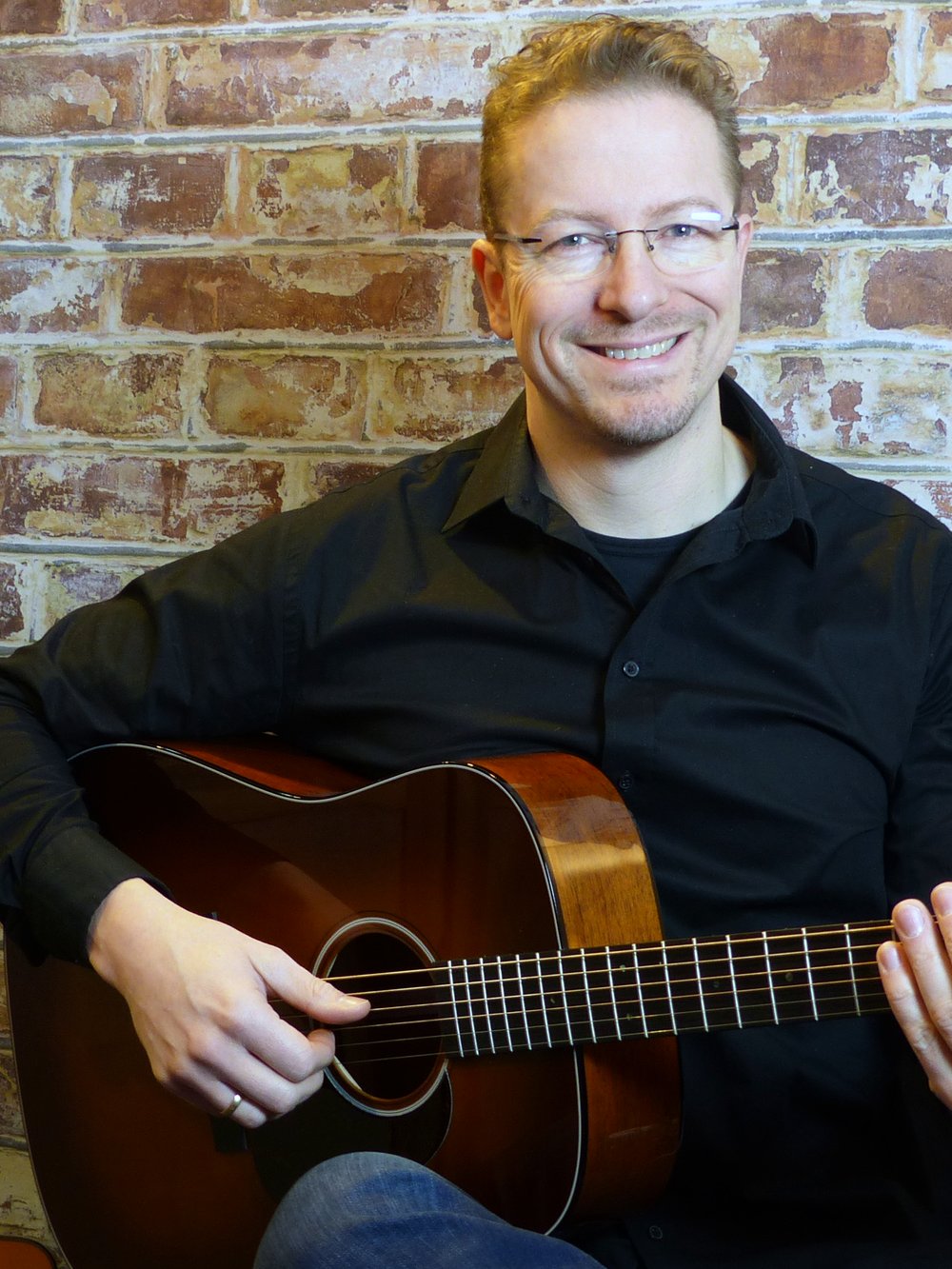 Alexander Stakenburg with an acoustic guitar