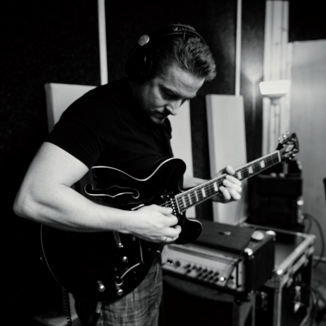 Alexander Stakenburg with a semi-hollow guitar in the studio
