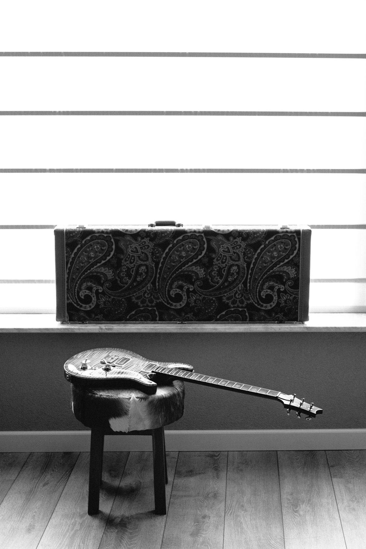 An acoustic guitar on a stool, ready for the lesson