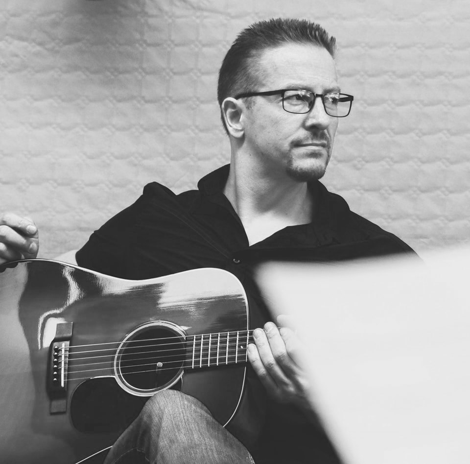Alexander Stakenburg met een staalsnarige akoestische gitaar